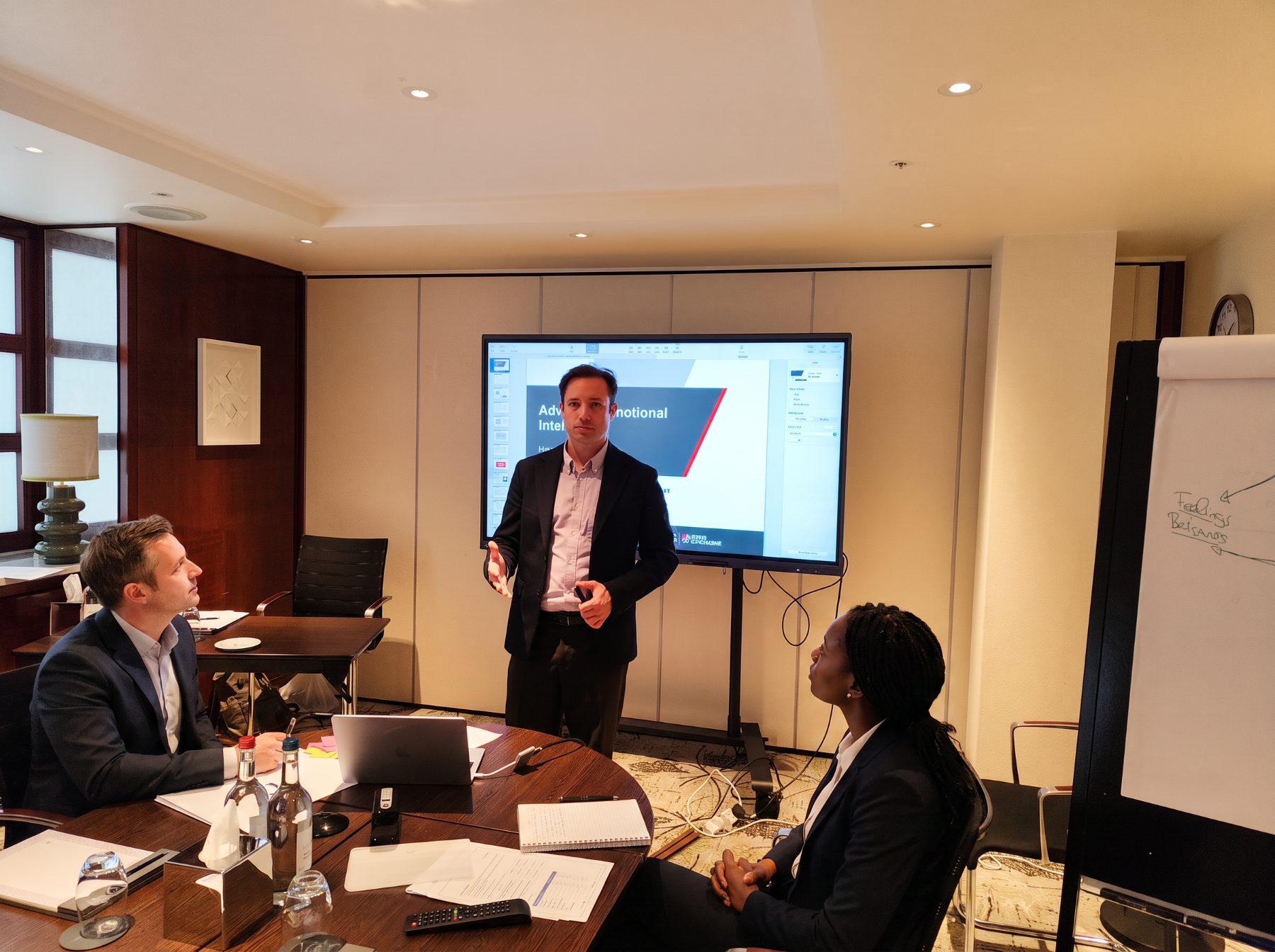 Mathieu facilitating a leadership session with two participants at a round table